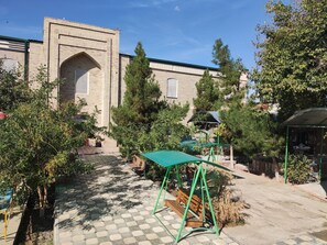 Un patio con un columpio, un banco y un mirador.