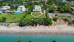 Une propriété située sur la côte, comprenant plusieurs maisons, une piscine et un accès à la plage.