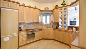 Une cuisine avec des meubles de rangement en bois, un lave-vaisselle, un four et un évier.