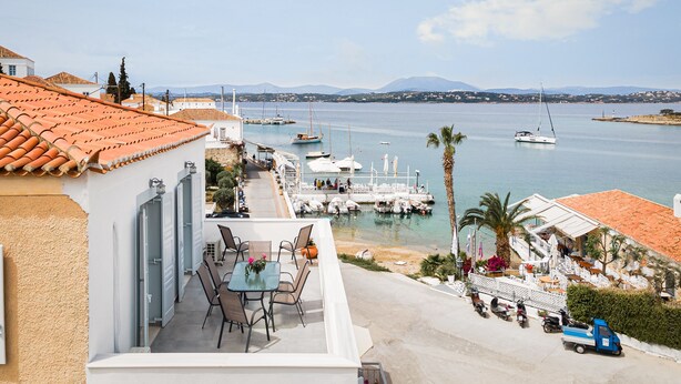 A coastal property with a terrace overlooking a marina, featuring boats and a clear view of the sea. - Old Port Spetses Mansion (Spetses)