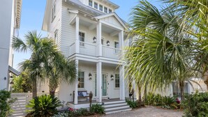 A two-story house with a balcony, surrounded by tropical plants. - Gulf Views-Resort Style Community! (Santa Rosa Beach)