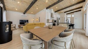 Un espacio moderno para vivir con una mesa de comedor de madera, un sofá amarillo y una zona de cocina.