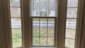 Ein Zimmer mit Erkerfenster mit Blick auf eine Straße und eine Rasenfläche.