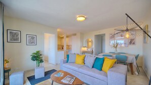 Ein modernes Wohnzimmer mit einer Couch, einem Couchtisch und einem Essbereich mit Tisch und Stühlen.