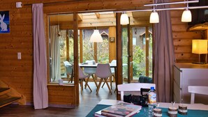 Un interno in legno con zona pranzo, ampie finestre e vista sull'esterno.