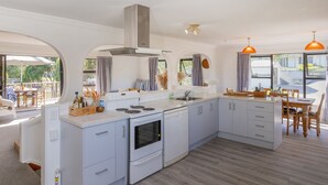 Una cocina moderna con armarios blancos, horno empotrado y una isla grande con fregadero.