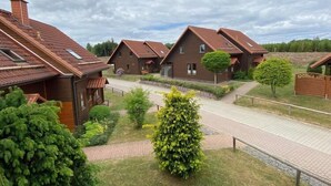 A row of modern, brown-roofed houses with a paved pathway and small trees. - Doppelhaushälfte in Hasselfelde (Hasselfelde)
