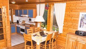A wooden cabin with a kitchen, dining area, and a small living space. - Doppelhaushälfte in Hasselfelde (Hasselfelde)