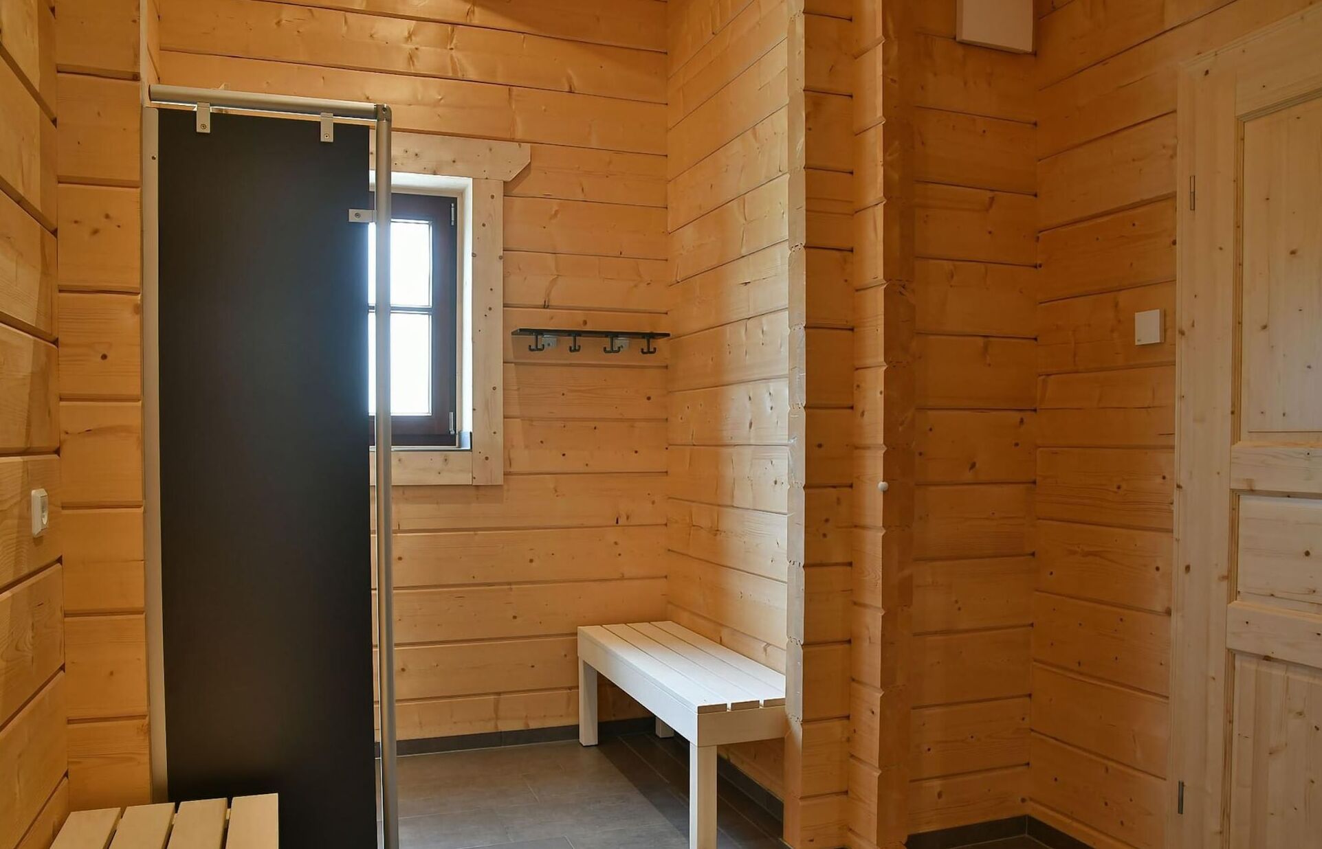 Una habitació de fusta amb una panxa, una porta i una finestra.