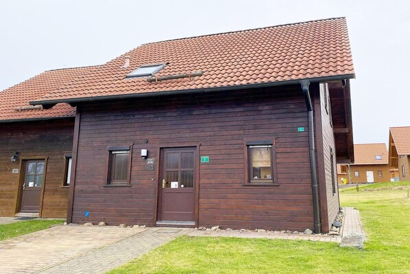 A wooden building with a tiled roof, a door, and windows. - Doppelhaushälfte in Hasselfelde (Hasselfelde)