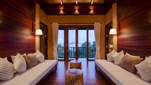 A room with two sofas facing a balcony, wooden floors, and a central round table. - Villa Lydia, Koh Yao Noi (Ko Yao)