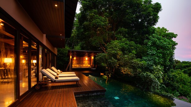 A wooden deck with lounge chairs, an infinity pool, and a glass-enclosed spa area. - Villa Lydia, Koh Yao Noi (Ko Yao)