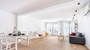 Un vaste espace de vie comprenant une table à manger, des chaises, un canapé et une petite table basse.