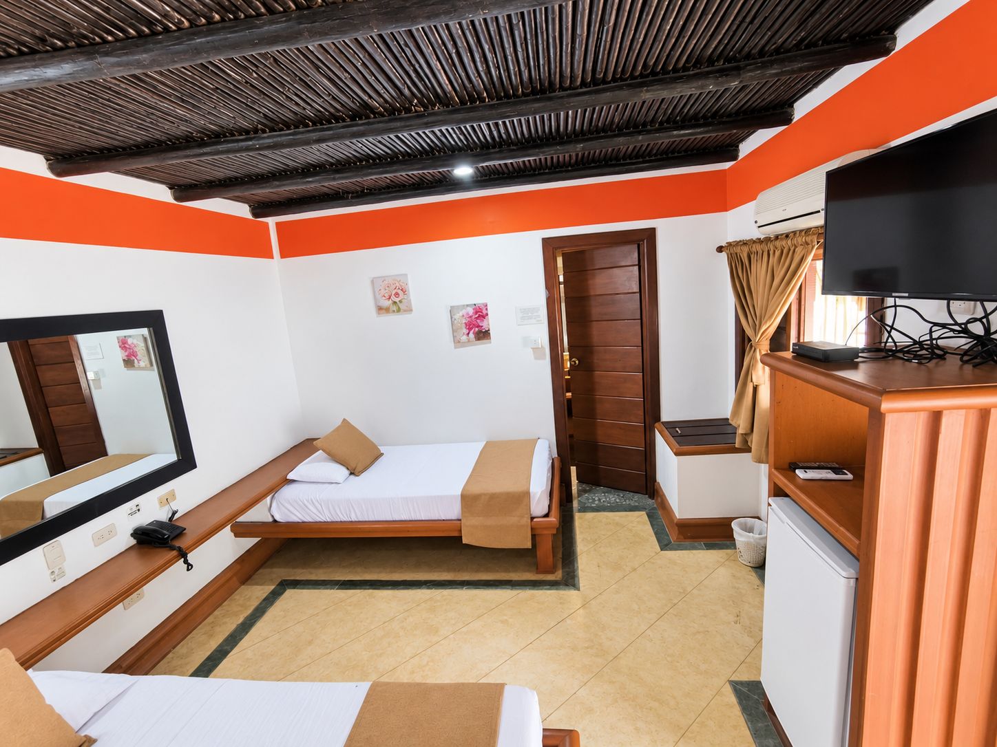 A hotel room with a bed, a desk, a television, and a wardrobe.