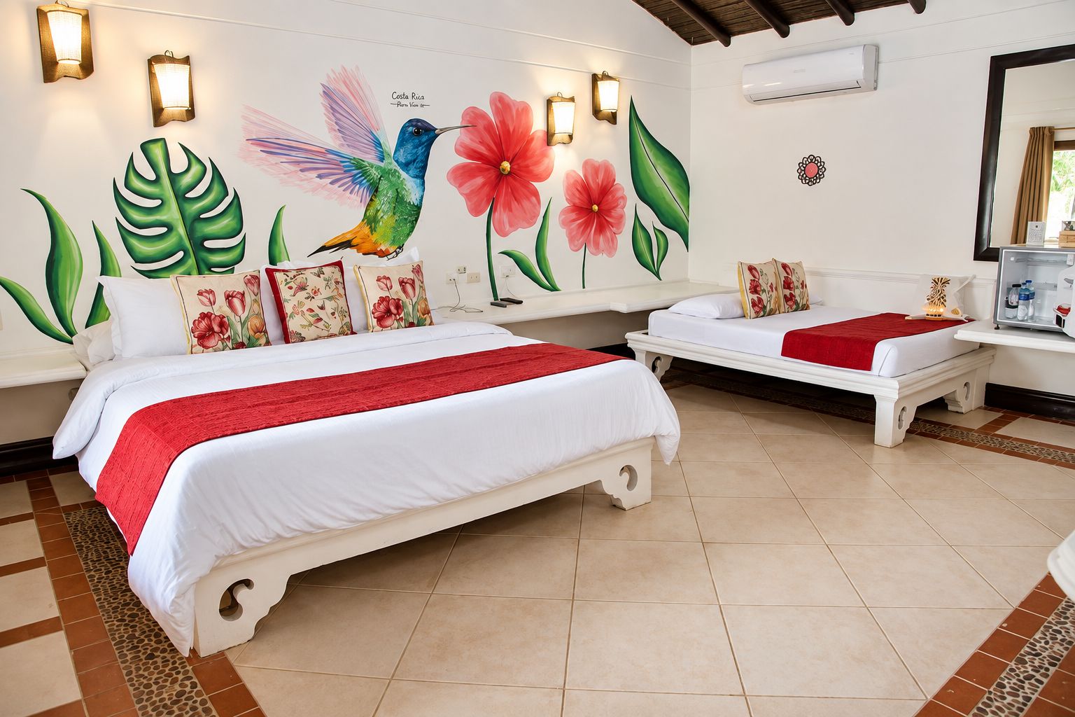 A hotel room with two beds, a mural of a hummingbird and flowers, and a minibar.
