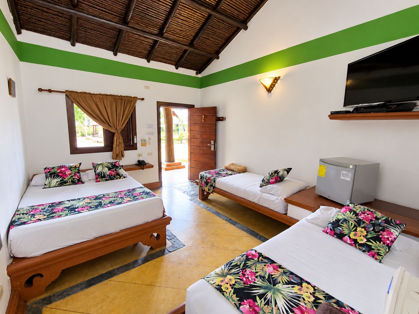 A hotel room with two beds, a television, a desk, and a minibar.