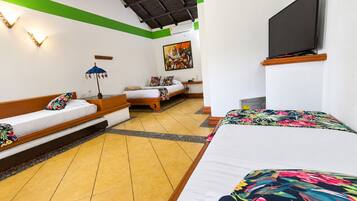 Una habitación de hotel con una cama, un sofá, un televisor y un cuadro en la pared.