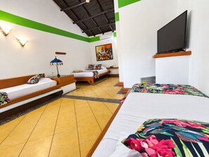 A hotel room with a bed, a sofa, a television, and a painting on the wall.