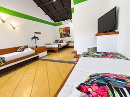 Una habitación de hotel con una cama, un sofá, un televisor y un cuadro en la pared.