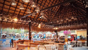 A covered outdoor area with a pool, lounge chairs, and tables. - Hotel Porton del Sol  (Santa Fe de Antioquia)