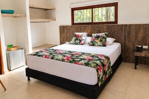 A bedroom with a bed, a wooden headboard, a window, a bedside table, and a small cabinet.