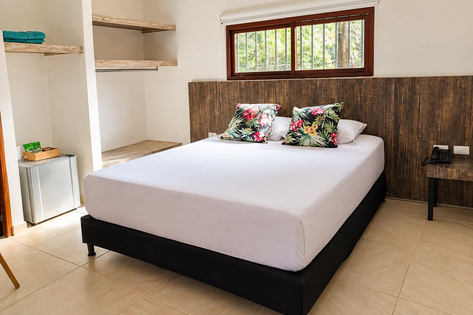 A bedroom with a bed, wooden headboard, a window, a bedside table, and a small cabinet.