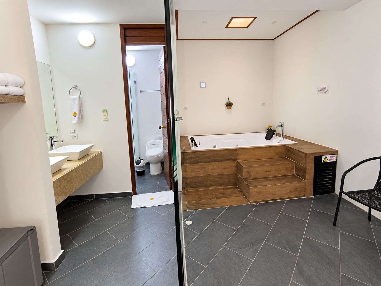 A modern bathroom with a large bathtub, a sink, and a toilet.