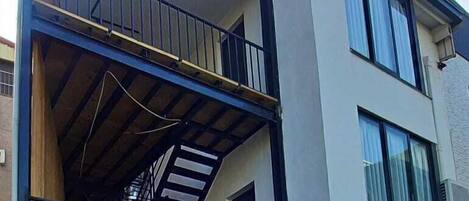 Un edificio moderno de dos pisos con un balcón en el piso superior.