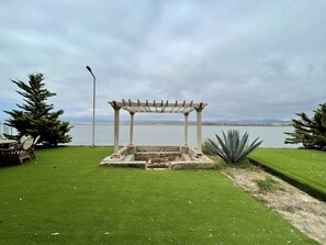 Eine Pergola mit Blick auf einen See und Berge im Hintergrund.