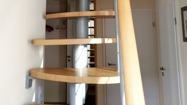 A spiral staircase with wooden steps and a metal railing. - FEWO in ruhiger Lage (Niedersachsen - Buxtehude)