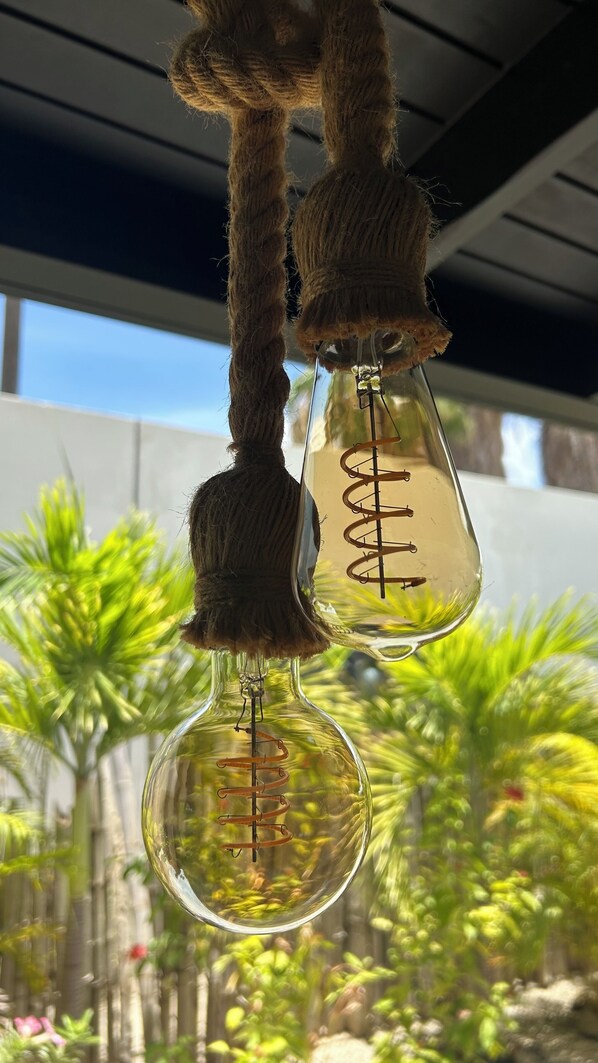 Two hanging light bulbs with a spiral filament design, suspended by a rope.