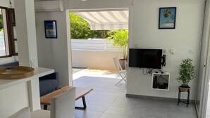 Un salon moderne doté d’un téléviseur, d’un coin salon et d’un balcon offrant une vue agréable.