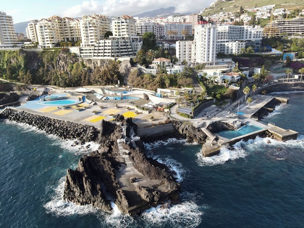 Ubicación cercana a la playa, arena negra, tumbonas y sombrillas