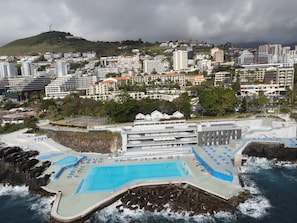 Ubicación cercana a la playa, arena negra, tumbonas y sombrillas