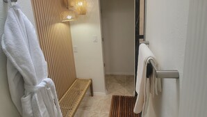 A bathroom with a white towel rack, a woven bench, and a wooden mat on the floor. - The Ritz serene spa sanctuary hot tub, mountain view, patio for the whole family (Las Cruces)