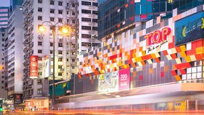 A brightly lit urban street with a prominent building featuring a colorful facade and a large illuminated sign. - Cozy hostel 2 pax, airport 30mins, 2mins Mongkok MTR,many tourist spots nearby. (Kowloon)