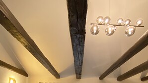 Una sala de estar con televisor, sofá, mesa de centro y candelabro.