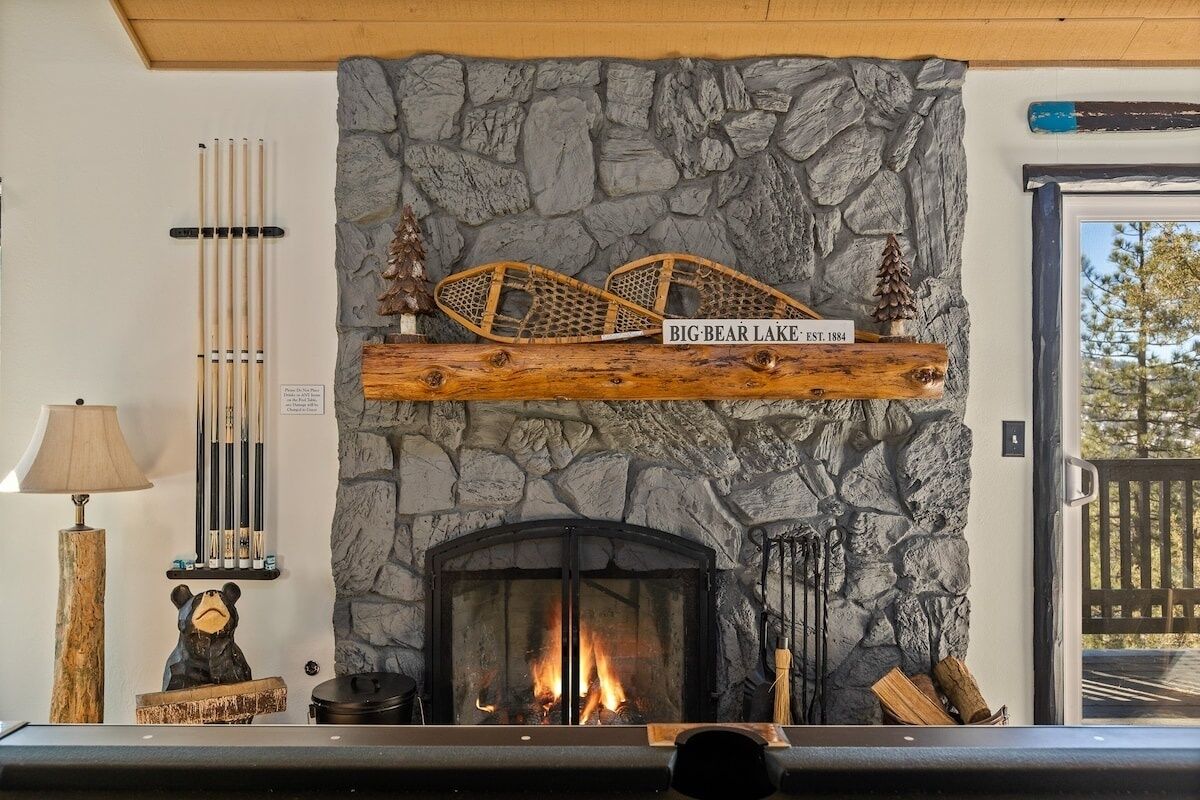 A stone fireplace with a bear figurine and a sign reading "Big Bear Lake Est. 1884".
