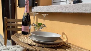 Una mesa de madera con una botella de champán Moët & Chandon, un bol y una copa sobre un mantel tejido.