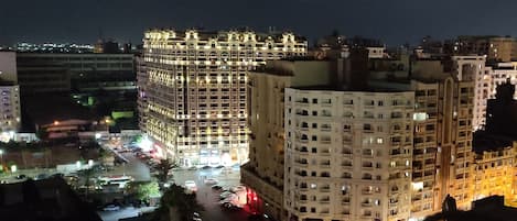 A multi-story hotel with a central courtyard, surrounded by other buildings.
