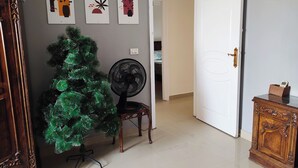 Un couloir décoré d’un sapin de Noël, d’un ventilateur et d’œuvres d’art mural.