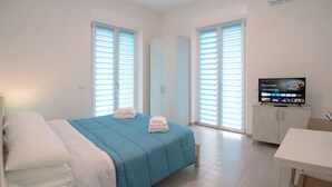 Una habitación de hotel con cama, televisión, armario y escritorio.
