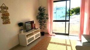 A living room with a TV, a potted plant, and a sign with motivational phrases. - Chabella - Charm Beach Lofts & Apartments - Centeanes (Carvoeiro)