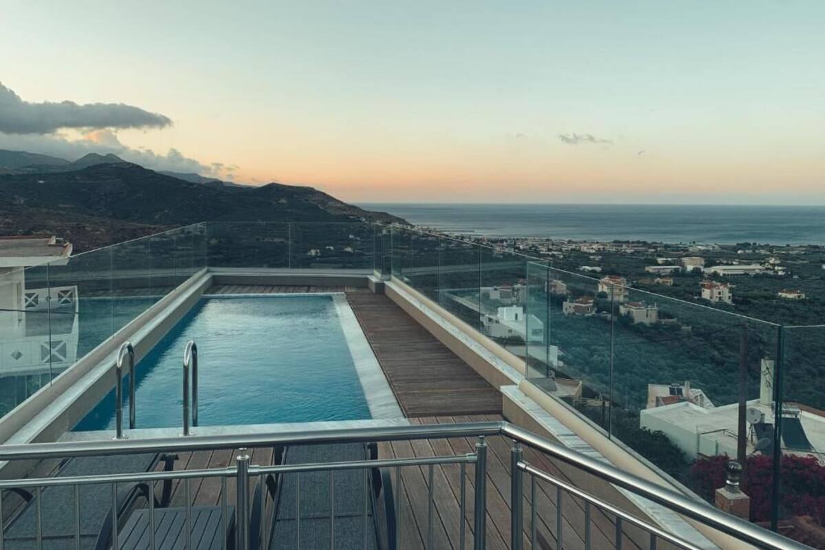 Ein Pool auf dem Dach mit freiem Blick auf das Meer und die umliegenden Gebäude.