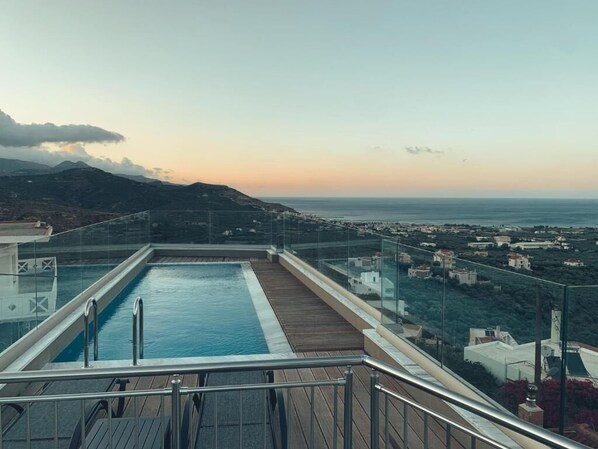 A rooftop pool with a clear view of the sea and surrounding buildings. - King Crimson Luxury Apartments (Platanias)