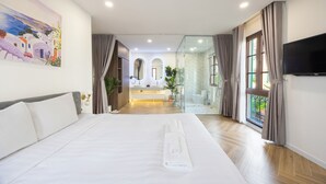 Une chambre d’hôtel avec un lit, une télévision, une salle de bain avec douche et une vue sur l’extérieur.