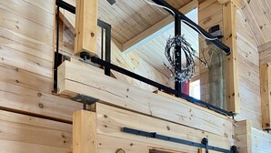 A wooden interior with a ski lift sign, a thermostat, and a power outlet.