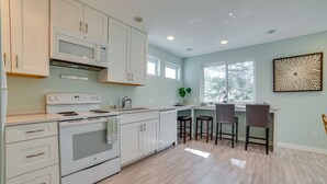 A modern kitchen with white cabinetry, a built-in microwave, and a large window providing natural light. - 13 Mi to Dtwn Seattle! 'The Nest' Apt w/ Balcony (Bellevue)