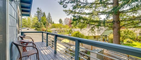 Eine Holzterrasse mit Geländer, einem Stuhl und einem Tisch.