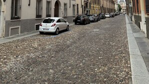 A cobblestone street lined with historic buildings, parked cars, and a clear sky. - Apartment in the historic center with private car parking (Mantova)
